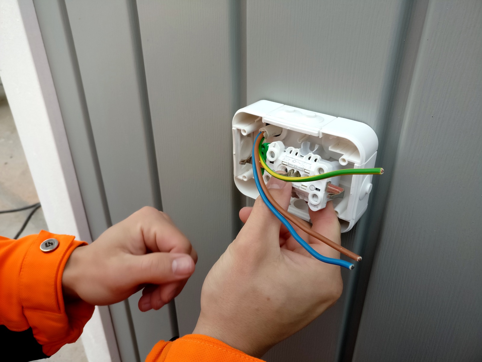 Elektriker verkabelt eine neue Steckdose in einer Wandinstallation