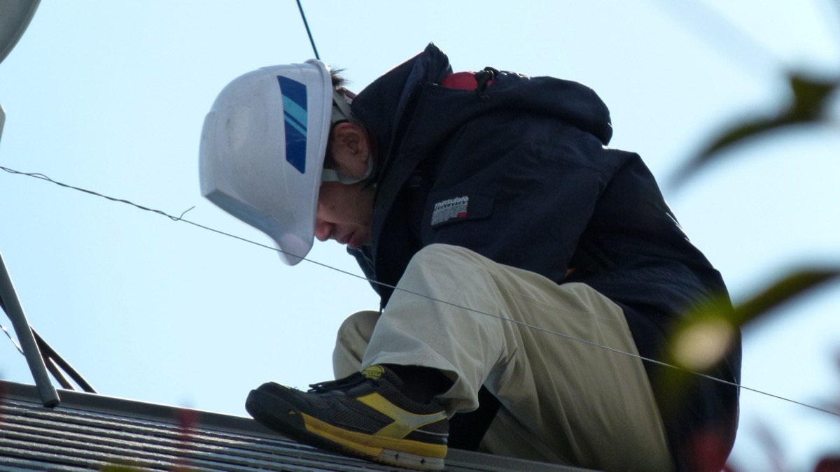 Techniker montiert PV-Module und Speicher bei einer Dachsanierung